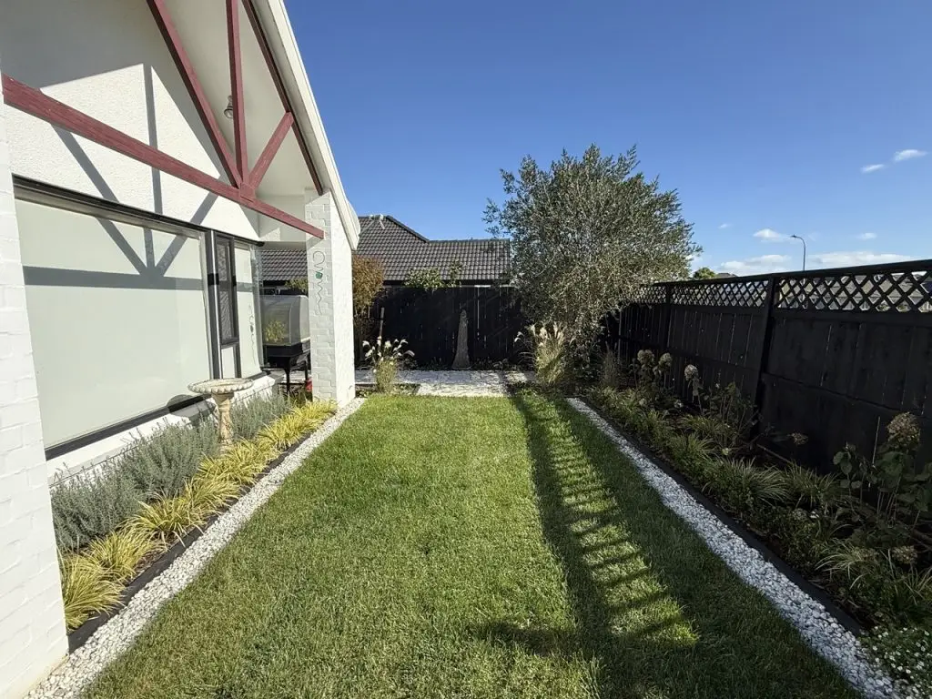 Contemporary outdoor garden patio with lawn and lush greenery designed by Visionary Outdoor Solutions